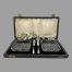 Main photo of cased butter dishes &knives displayed inside their original fitted case. The lead crystal butter dishes are to the left and right inside the case with the small silver butter knives slotted vertically at the centre. The case is in very good condition except for mild foxing of the silk to inside lid. A spray of white orchids is between the lid silk and fitted velvet area for display purposes only.