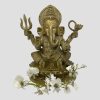 Main photo of antique bronze Lord Ganesha shown against a light grey background and facing forward at the camera. There a spray of white orchids laid around his feet. This bronze has a golden hue and is very well presented.
