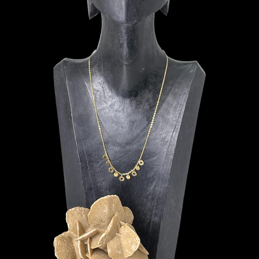 Main photo of gold disc chain necklace displayed on a dark wood display stand and shown forward facing. The chain is 410mm long so will hang near the collar bone. There is a rock of natural desert rose in the left foreground.