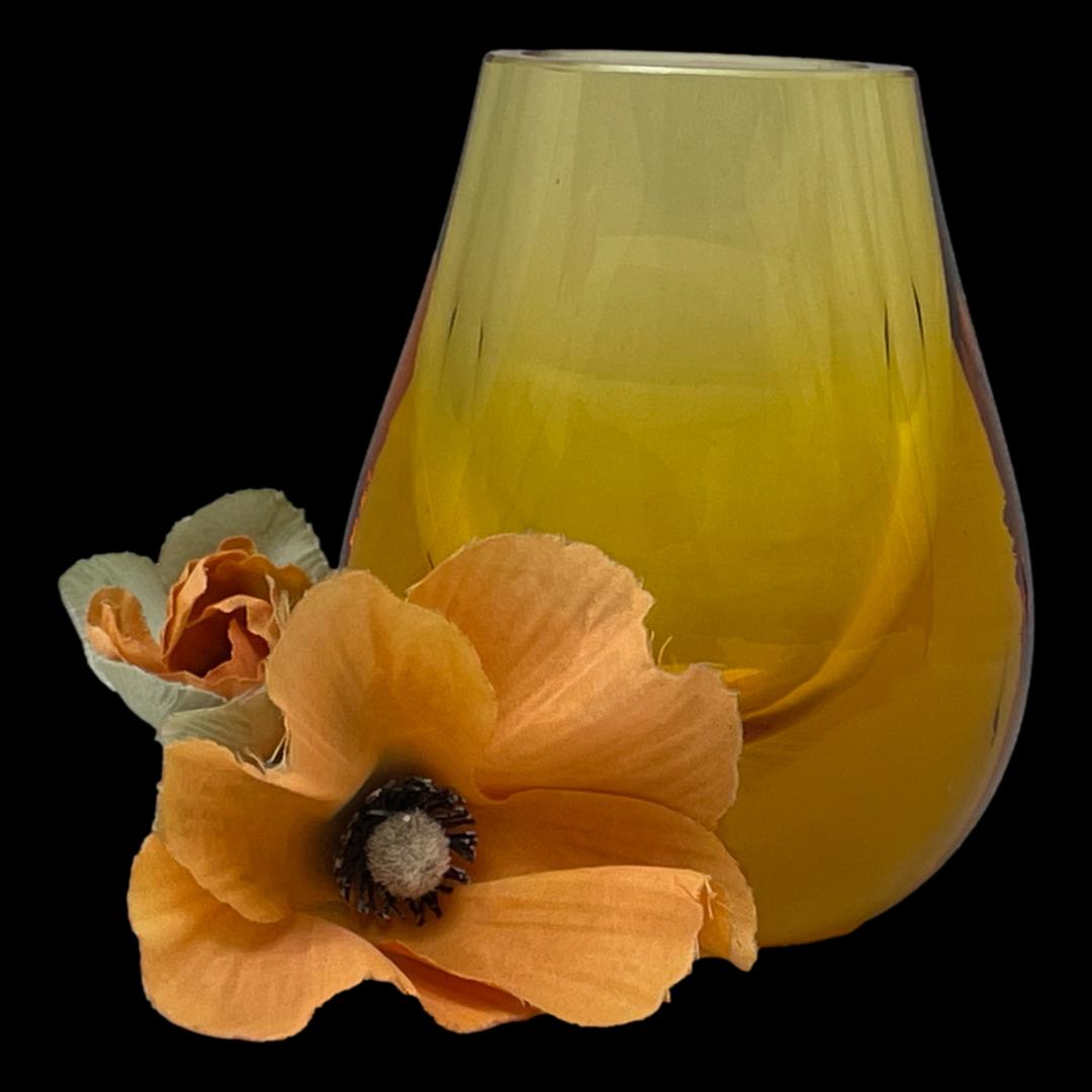 Main photo of Whitefriars amber hambone vase seen with the widest side on display. Like a hambone, this vase is narrow at the side. The heavy base provides excellent stability. There is a poppy flower to the bottom left of the vase for display purposes only.