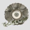Main photo of antique Persian bowl shown propped up with the centre of bowl on display. A spray of white orchid flowers lays across the bottom. The pierced and chased sections around the bowl are visible with a nice rose detail to the centre of the bowl.