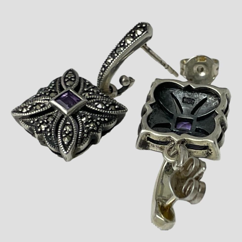 Photo of both earrings laid on a flat surface with one facing upward and other face down. Butterfly has been removed on one facing up.