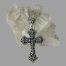 Main photo showing the cross leaning against a rock of natural quartz crystal. The side displayed is the more intricate pierce worked side and most likely the front The bail is as intricately pierced as the cross and part of the chain is visible to the top laid on the crystal.