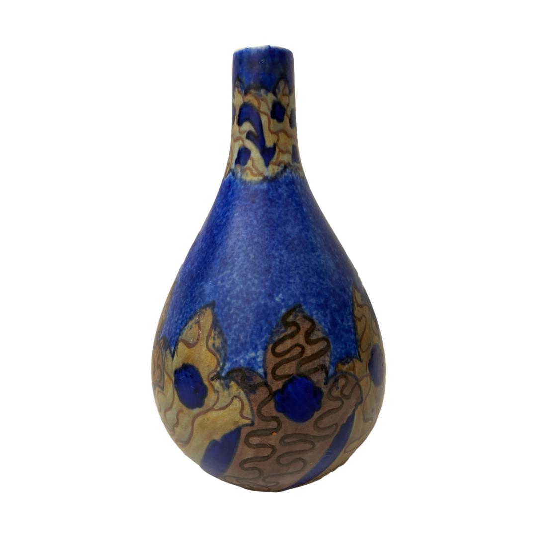 Main photo of Chameleon Ware vase seen from an eye level against a white background. The vase is a teardrop shape with a beautiful cobalt blue base colour and decoration around the neck and base in dusky red and orange with some cobalt blue coming through.