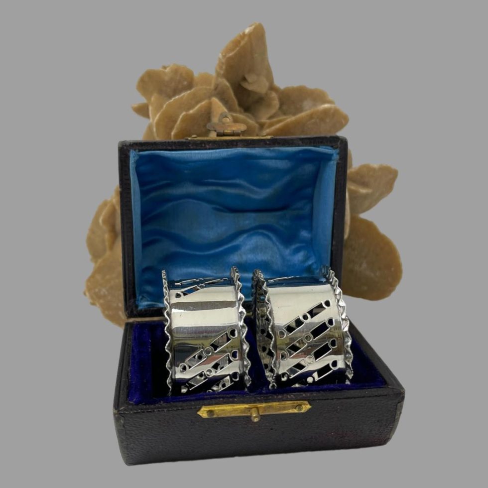 Main photo of sterling silver napkin rings displayed inside their fitted case. The empty cartouches are visible on the rings. The inside of case lid is a beautiful shade of blue satin in very good order. A great gift item.