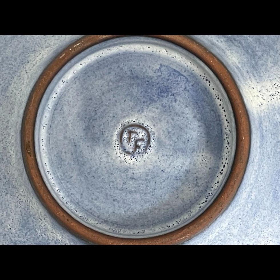 A close up photo of the artists initials on the base of Tessa Fuchs elephants bowl.