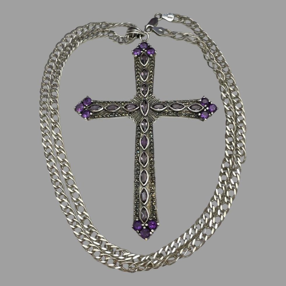 Photo of large cross laid on a flat surface with the chain laid out in a circle around it.