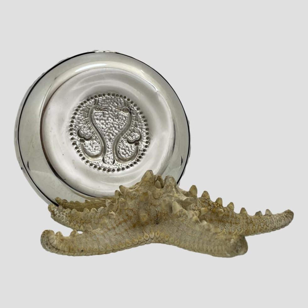Photo of the sterling silver seahorse dish displayed upright on top of a starfish and showing the back of the dish.