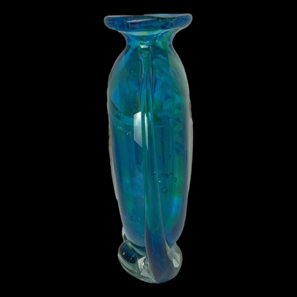 Photo of unsigned Mdina glass vase seen from a side angle. The vase has 2 flat sides so looks thin from this angle.