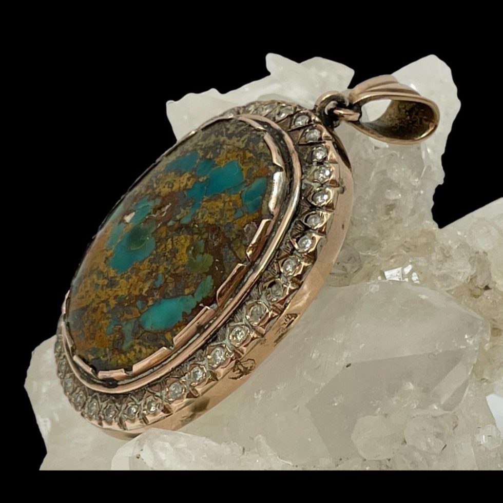 Photo of the pendant still displayed on some quartz crystal and seen this time from a slight side angle.