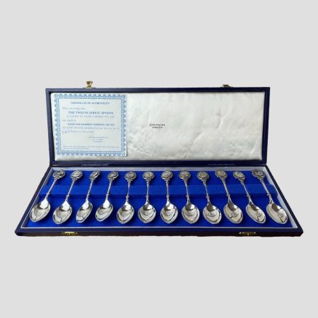 Main photo of the sterling silver zodiac teaspoons displayed inside their fitted case.. The case is quite long in order to house all 12 spoons! There is a certificate of authenticity attached to inside of lid on the left hand side detailing the artist and silversmiths details. The condition of the spoons as well as the case is in very good order.