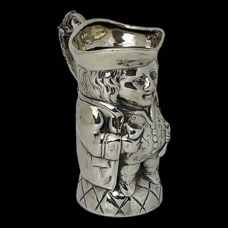 Main image of Edwardian silver Toby jug with front facing to the bottom right corner. The photo is taken from a little height showing a little of the hat interior.