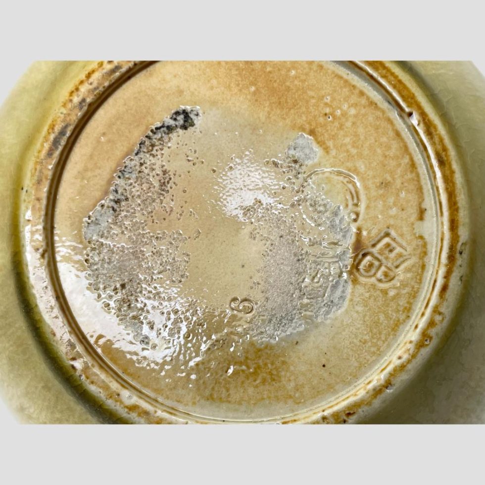 A close up of the vase base showing the worn makers marks which are only just visible. The artists initials EB are clearly visible to the right.