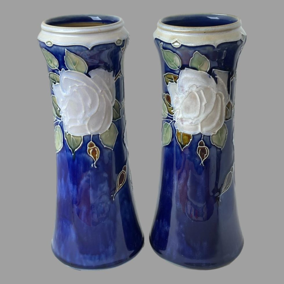 Photo of tall Doulton rose vases this time with roses displayed at top.