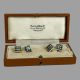 Main photo of 18kt gold sapphire cufflinks displayed inside the box which is included but not original. The sapphire ends of both ends of cufflinks are facing up and on display.