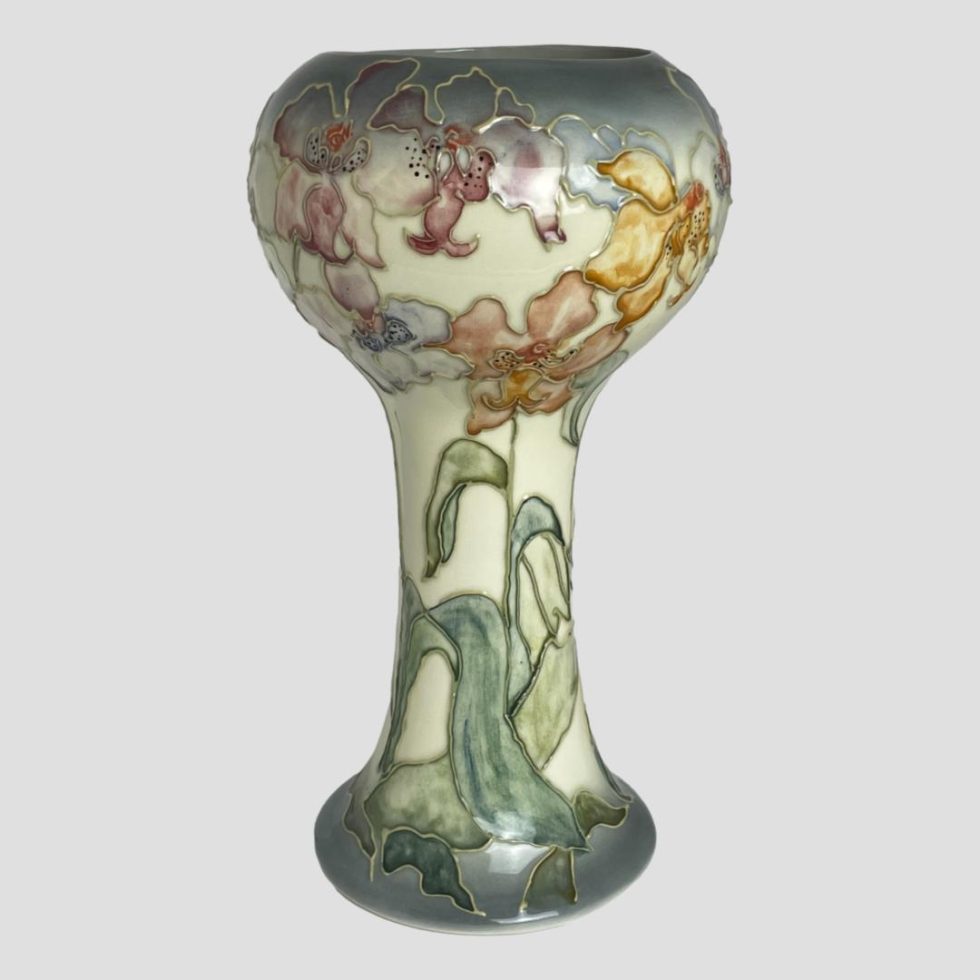 Photo of Chris Lucas Studio Pottery vase seen from an eye level with the side of most colourful flowers in red orange and yellow on display.