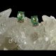 Main photo of gold emerald diamond studs displayed on top of a rock of crystal quartz with the earring fronts facing forward. The green colour of these emeralds is very unusual-more pale than regular emeralds. The diamonds are set slightly back from the emeralds but have intense sparkle.