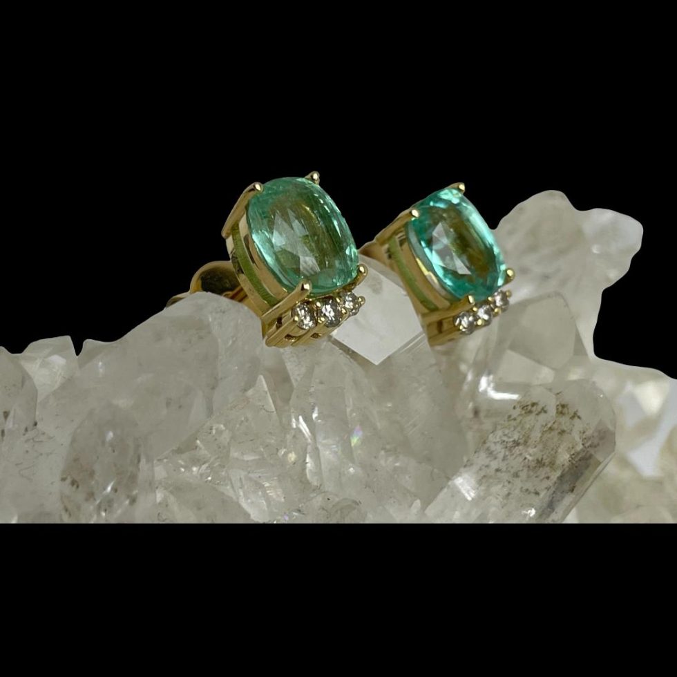 Photo of gold emerald diamond studs still displayed on rock of crystal quartz and earring front faced towards the right.