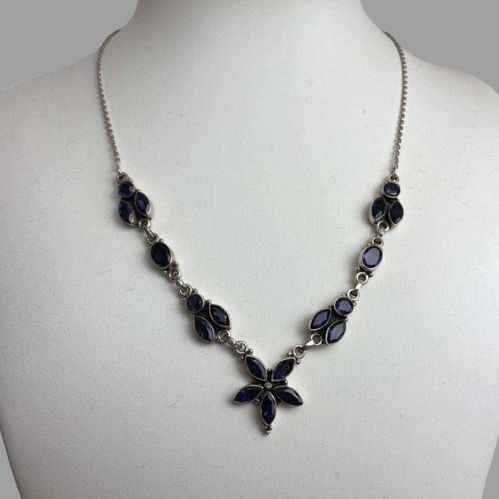 Photo of sterling silver iolite necklace displayed on a stand with the necklace front forward facing.