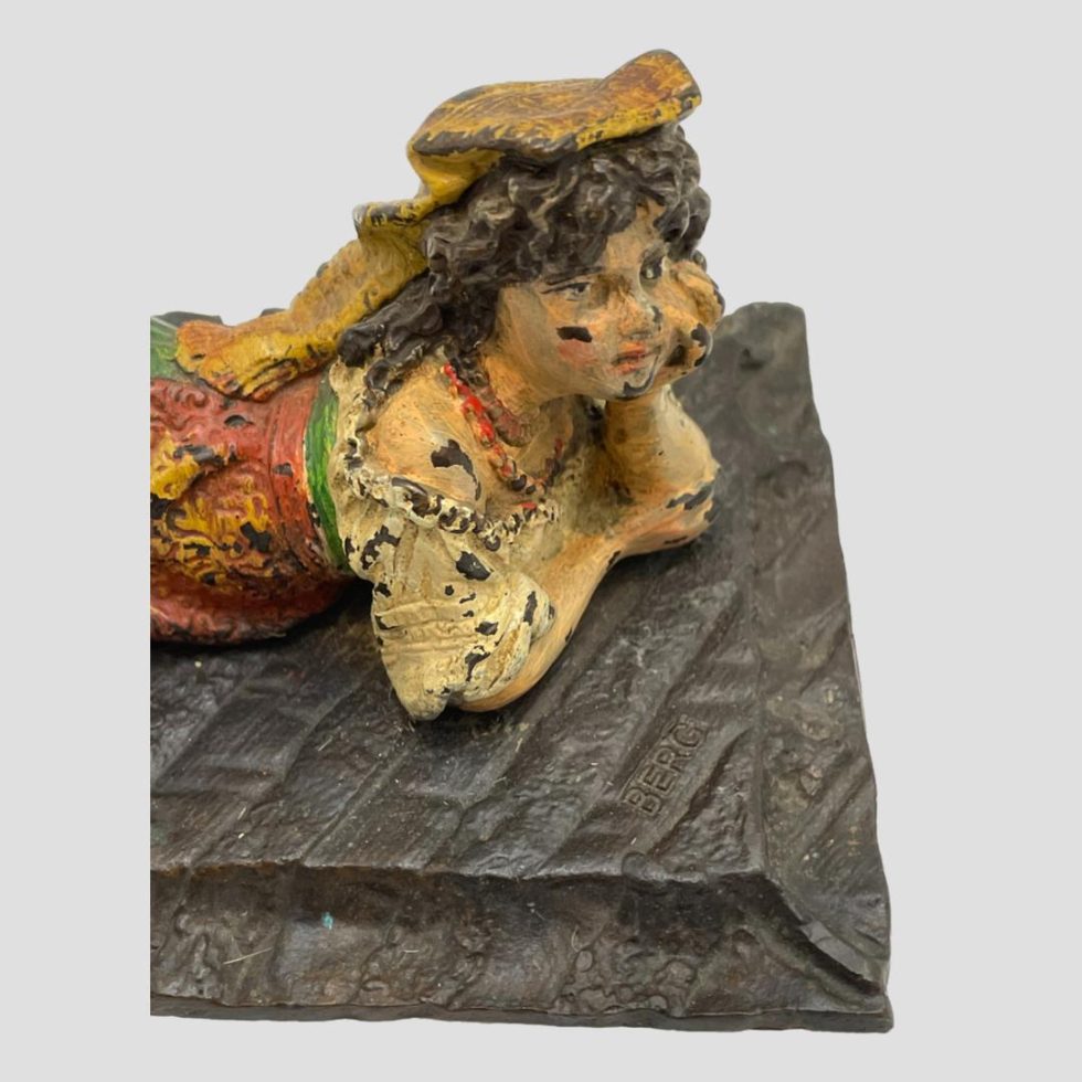 A photo in close up of the vintage bronze Bedouin girl looking diagonally down slightly at face area. From this angle, it appears as though she is looking straight ahead.