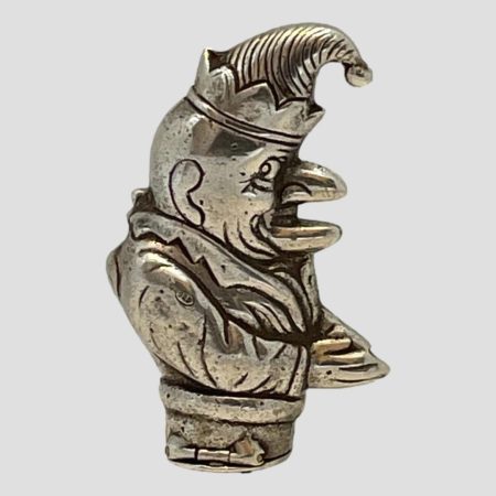 Main photo of vintage silver Punch vesta seen from a side angle with Mr Punch facing right. The 925 hallmark is just visible to top of his arm here. He is wearing a floppy hat with a bell on top and has his hands together in front of him. His mouth is open and his lips resembles a birds beak.