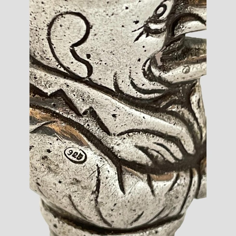 Close up photo of the 925 hallmark on one arm of vintage silver Punch vesta.