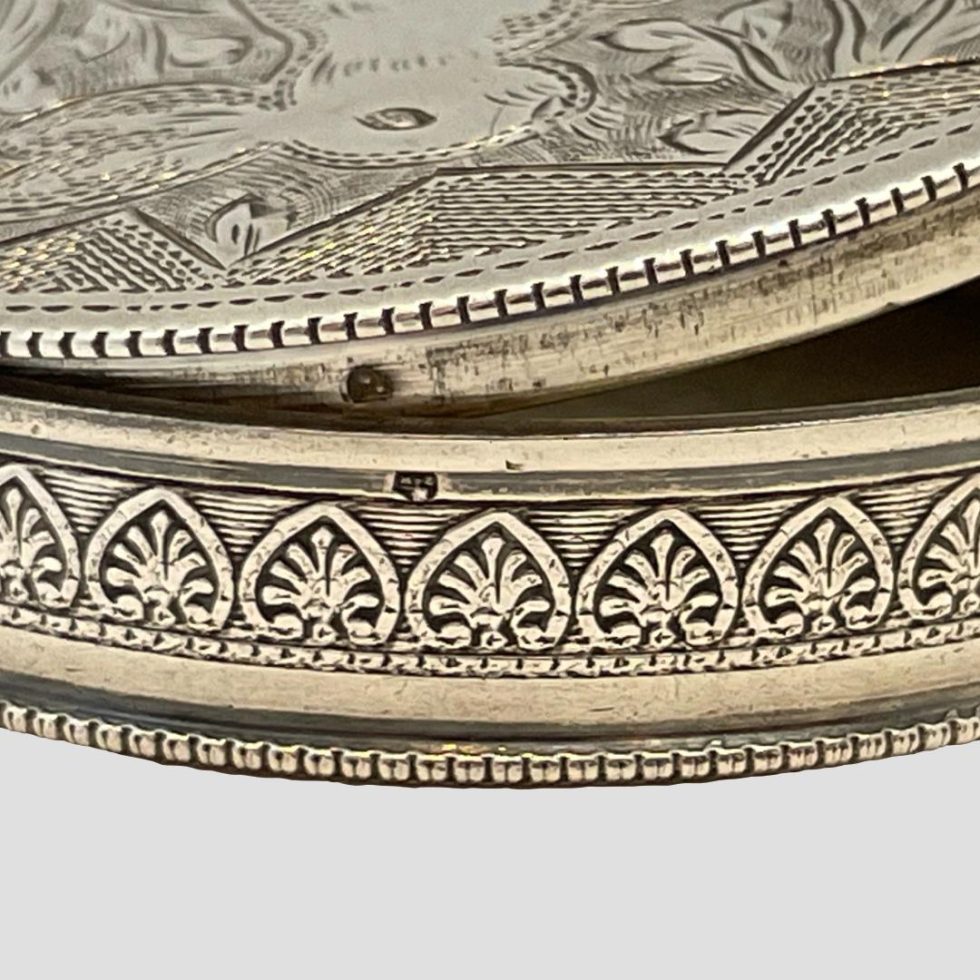 Close up photo of the single hallmarks to the inside rim of lid and outer rim of 1930s Austrian silver compact. The 2 separate single hallmarks are almost in alignment.