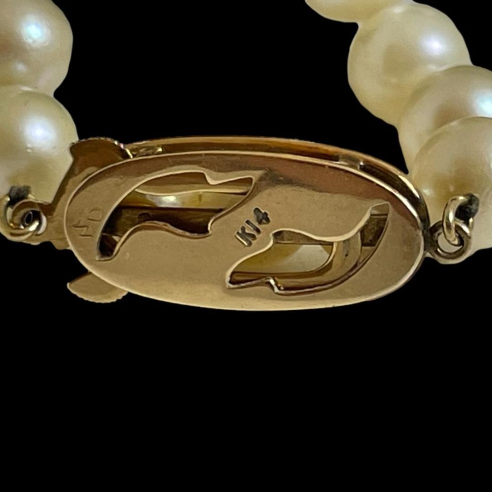 Close up photo of the back of clasp of long cultured pearl necklace showing the 14k hallmark.