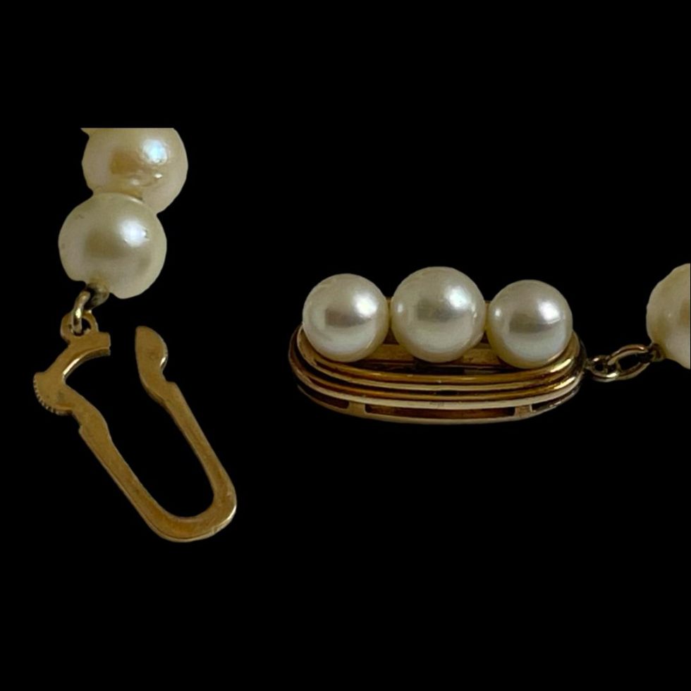 Close up photo of long cultured pearl necklace with the clasp area again this time showing the hook fastener completely removed and to the left.