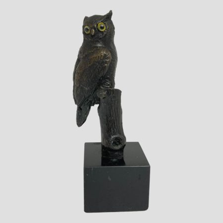 Main photo of vintage small bronze owl with the owls head facing the camera so both its big eyes are facing forward. The birds breast is facing to the right so only one side of the birds body is visible. At this angle, the branch it is sat on is not visible. Beautifully made little owl.