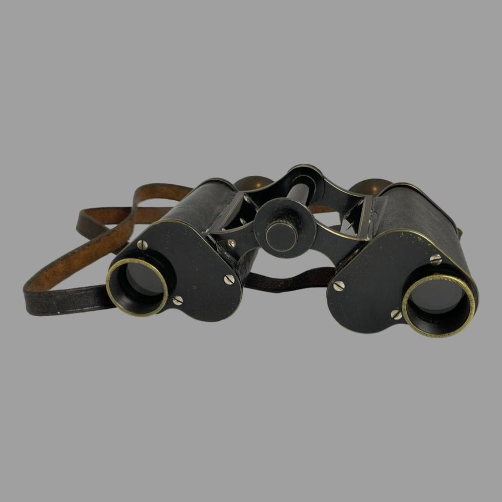 Photo of Carl Zeiss Jena binoculars laid on a flat surface with the lens end in the foreground. The binoculars have been extended widthways.