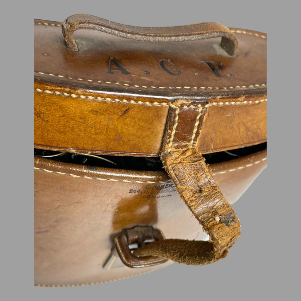 A close up photo of the worn strap at the front of Carl Zeiss Jena binoculars case.