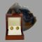Main photo of carved citrine gold earrings displayed inside their lacquer wood box. There is a slice of natural agate behind the open box.