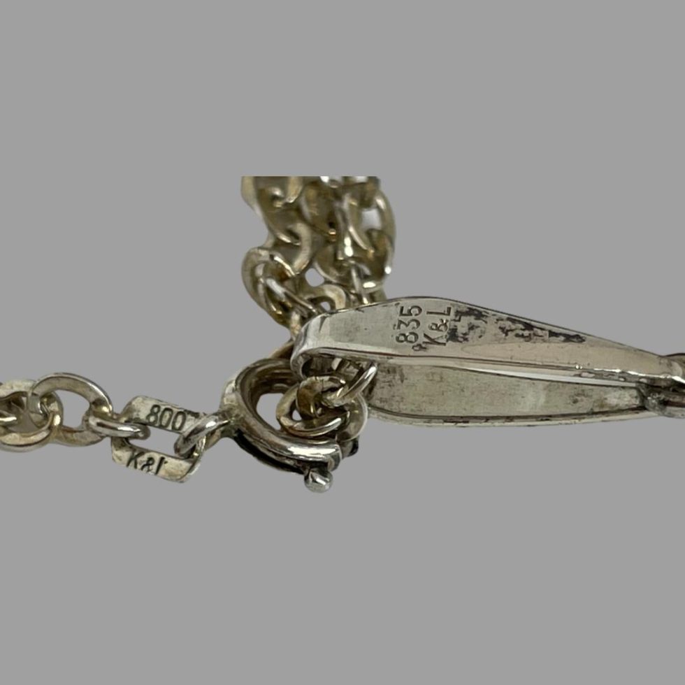 Close up photo of the clasp and bail areas of the 1960s Kordes & Lichtenfels necklace showing the 800 K & L hallmark to the clasp and 835 K & L to the bail.