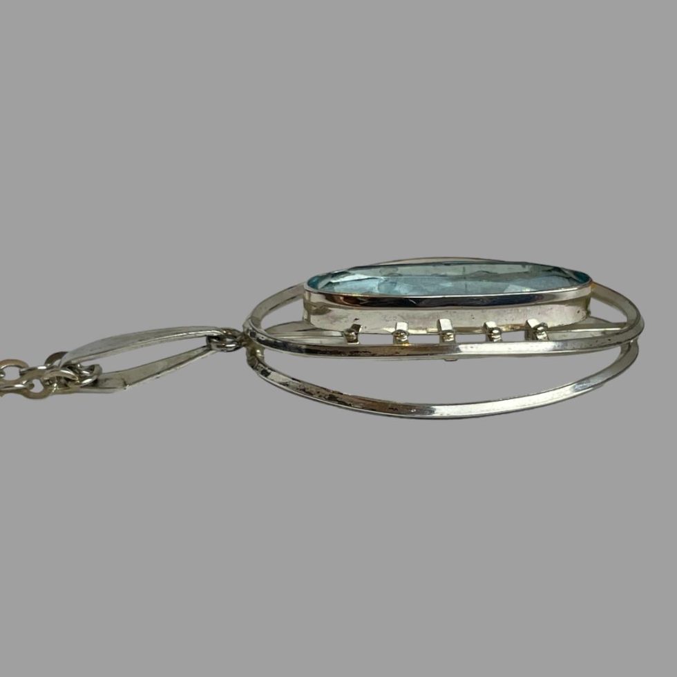 Photo of the pendant on the 1960s Kordes & Lichtenfels necklace shown laid flat and from the side. At this angle, the double silver frame of the pendant is clearly visible.