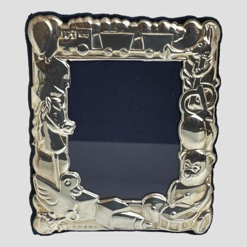 Main photo of toy theme photo frame seen with the front of frame forward facing. The frame is made up of toys from teddy bears, hobby horse, trains amongst others and would be ideal for displaying a child or grandchild's photo. Would be a lovely gift item to give to parents or grandparents with photo included. Hallmark is just visible to bottom left below the rubber duck and building blocks.