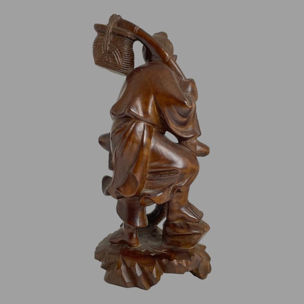 Photo of back of carved wooden Oriental fisherman seen from the back.