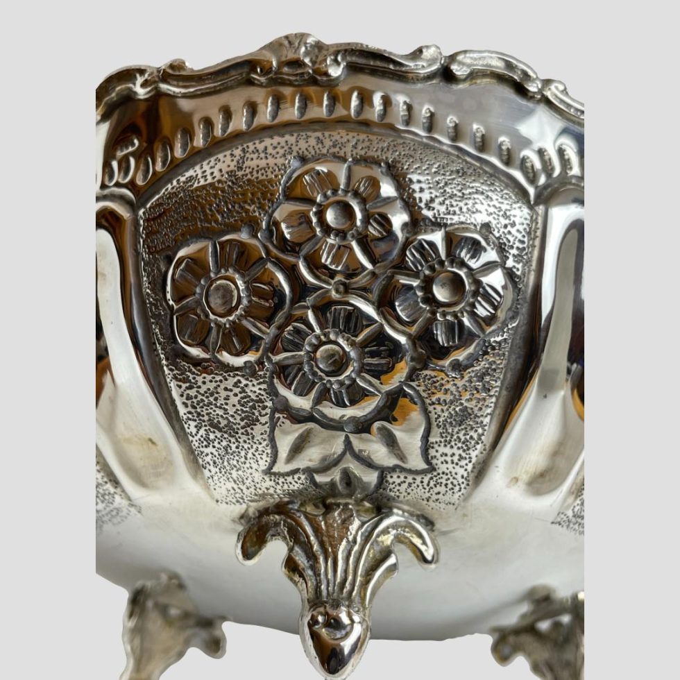 Close up photo of one dog rose panel and one tripod foot of 835 Continental silver bowl.