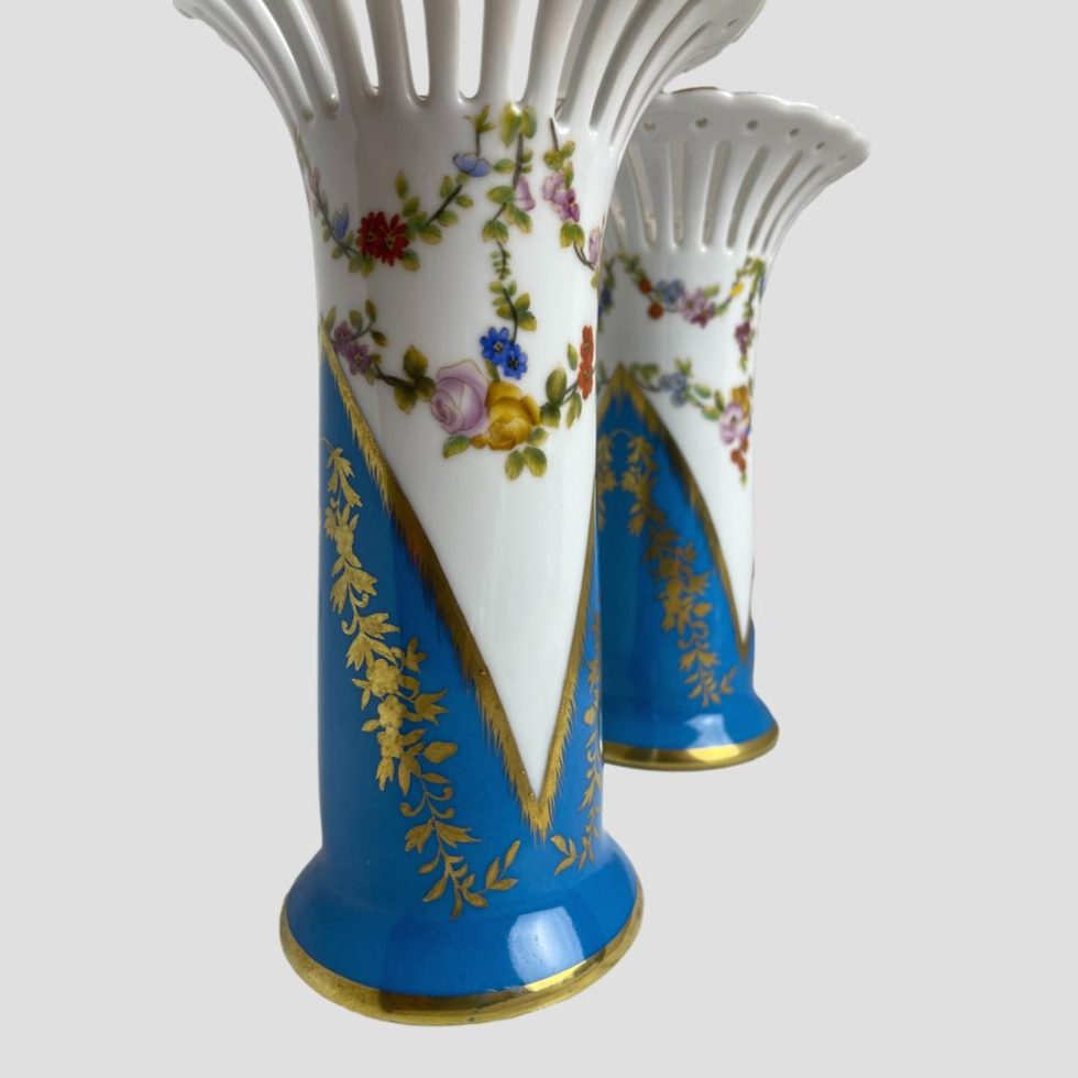 Close up photo of the areas of the vases below the flared rim. The vase in left foreground has the tapered white tip reaching into the turquoise and the back right vase shows half the tapered tip of turquoise .