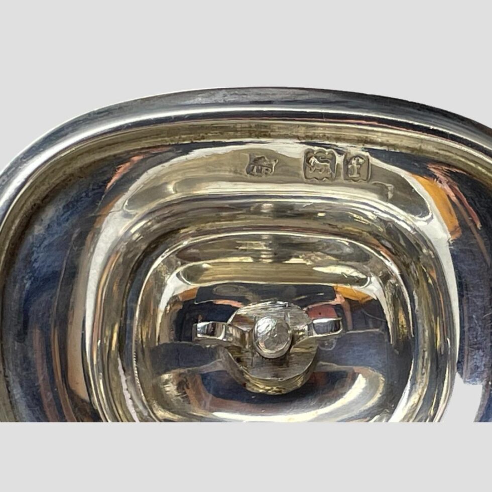 A close up photo of the shorter and clearer hallmark on the inside of Edwardian silver tea caddy lid.