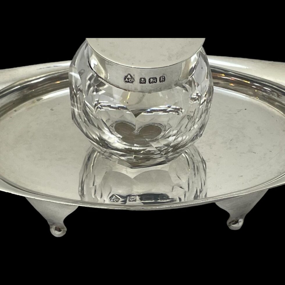 Photo of Asprey silver & crystal inkwell showing the hallmark around the rim of front of the inkwell lid and the hallmark on the inside of the stand at the centre.