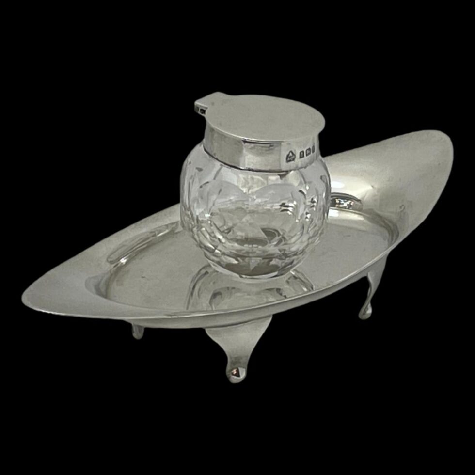 Photo of Asprey silver & crystal inkwell seen from a diagonal side angle looking down from a slight height