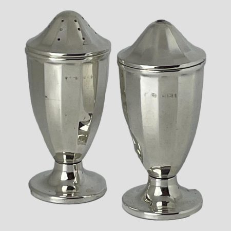 Main photo of silver bakelite salt & pepper seen almost from an eye level withpepper pot slightly back from the salt. The pots are a lovely streamlined shape with a round foot base making them very comfortable to hold and use.