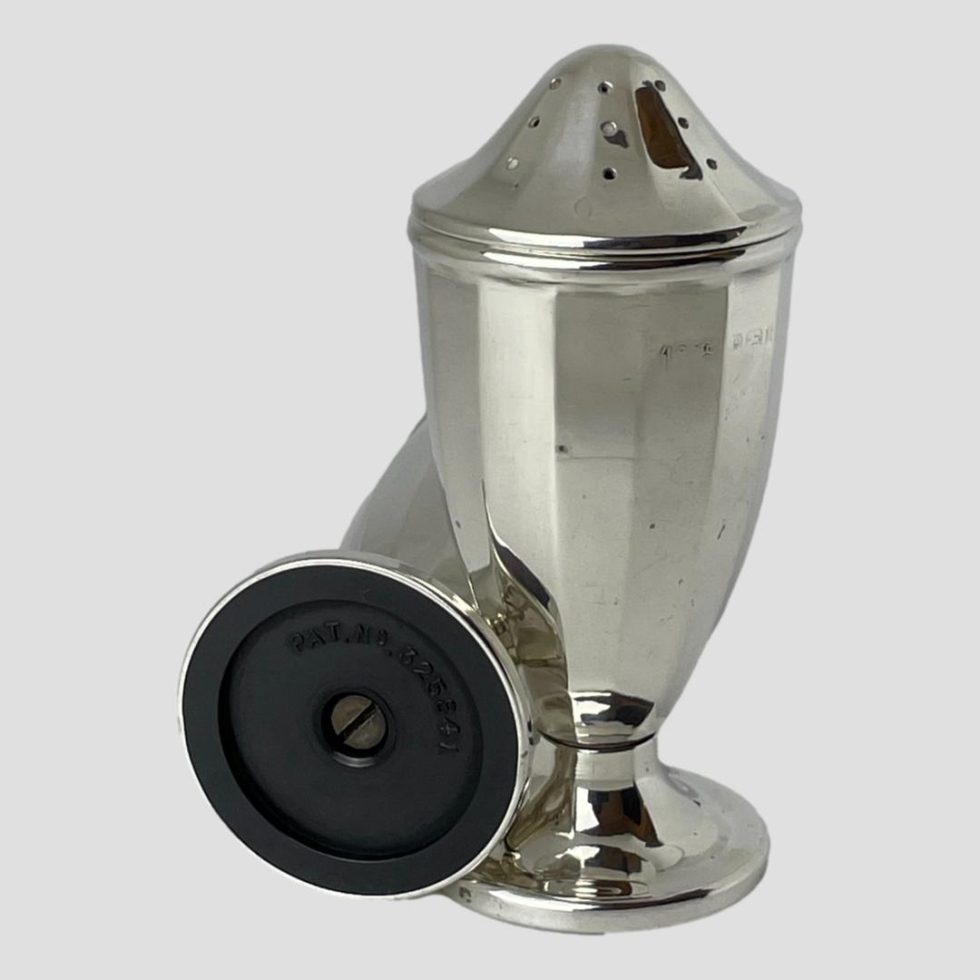 Photo of silver bakelite salt & pepper shoping the base of the salt on the left and pepper upright on right. The base of salt says Made in England.