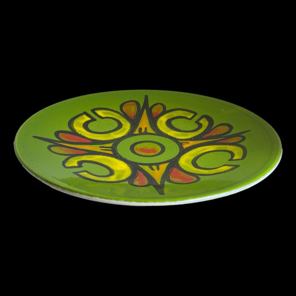 Photo of large Poole Delphis dish seen laid on a flat surface and looking diagonally down to the centre from a slightly raised angle.