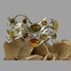 Main photo of silver multi amber cuff shown displayed on top of a rock of natural desert sand rose and with the cuff forward facing. Each different piece of amber is housed in their individual silver setting so to the centre there are the 2 largest pieces of amber in cognac and moss green of oval shape in an oval silver frame. There are 2 small round pieces to left and right of top oval amber and 2 smaller ovals either side of the lower central oval amber. There are 2 square set egg yolk amber pieces and 2 more smaller moss green oval ones opposite these. This is a really lovely and cleverly constructed cuff bracelet.