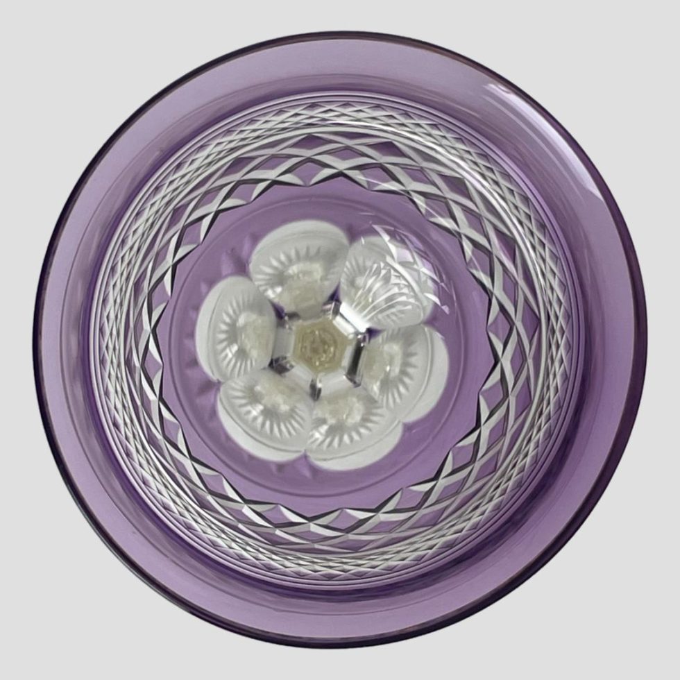 Photo looking straight down into the bowl of the rare amethyst crystal glass. The daisy shape base is visible with the 2 areas of different sized criss-crosses. A truly delightful glass.