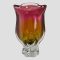 Main photo of Josef Hospodka vase seen from an eye level. The vase has a tulip flower head shape with clear glass base, amber glass lower body and pink ruby coloured upper part. The rim is also clear glass.