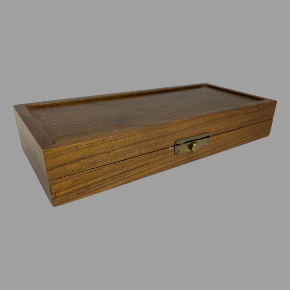 Photo of the box shown closed and set at an angle with the opening side facing towards the bottom right corner.