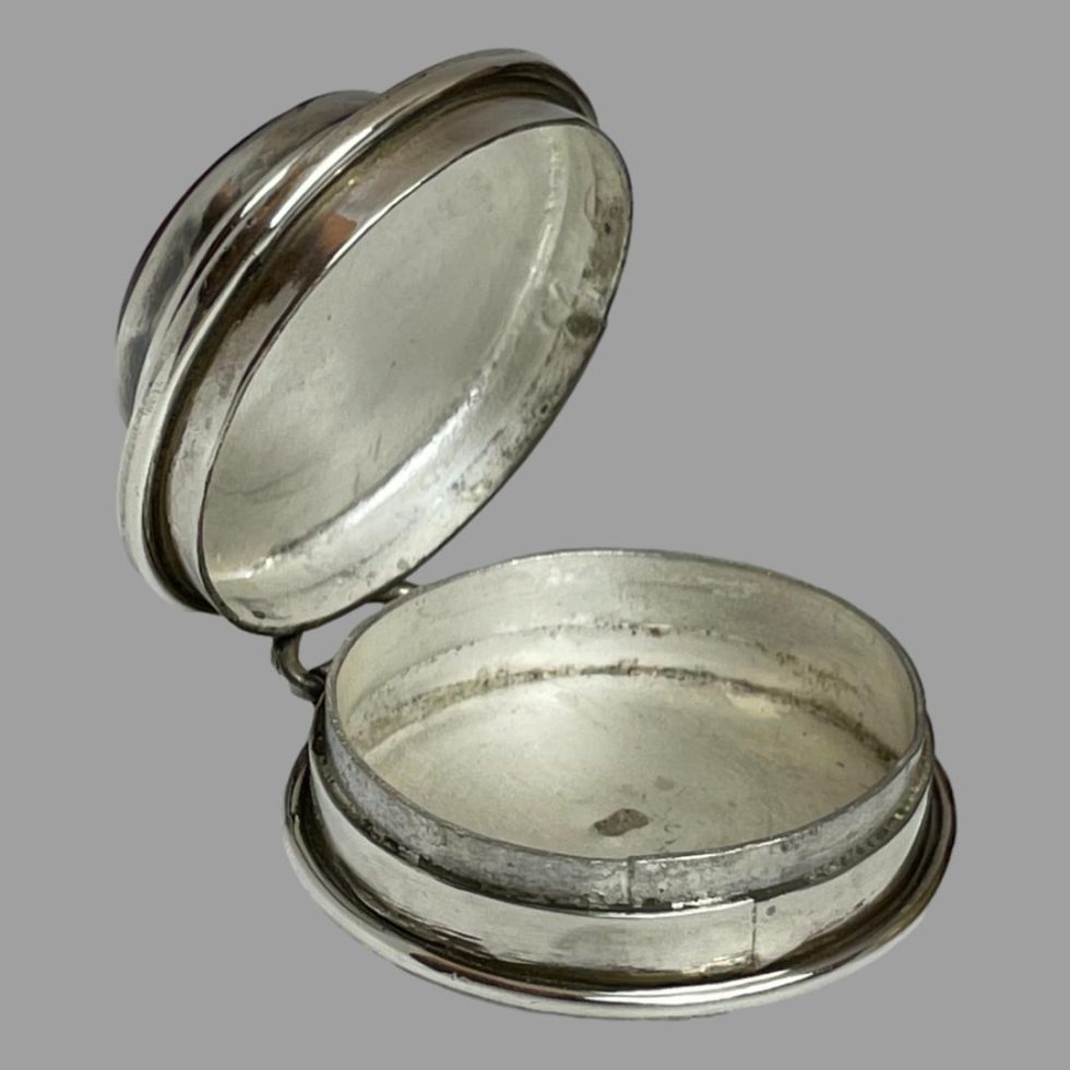 Photo of silver & carnelian pill box shown with lid open revealing the interior (which is not as deep as the exterior makes out!) The 925 hallmark is visible to the centre.